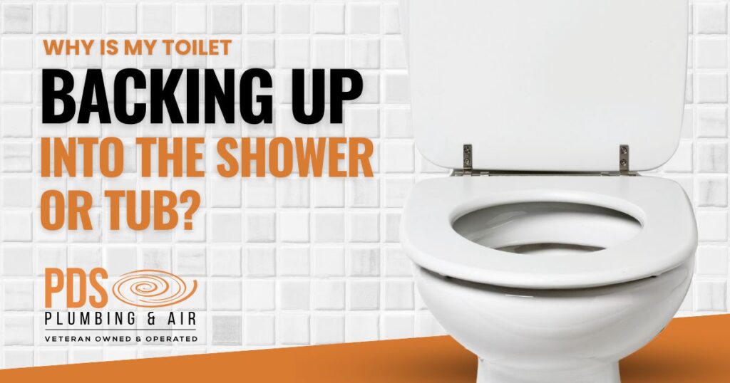 Open toilet in front of white tiled wall with text asking, "Why is my toilet backing up into the shower or tub?" plus a PDS Plumbing & Air logo below—explore issues like slab leak vs pipe leak that could be causing your plumbing problems.