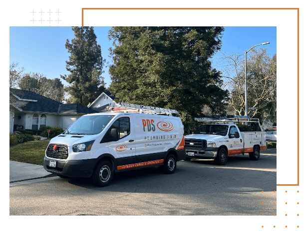 Two utility vehicles with "PDS Dynamics" logos are parked on a residential street in front of a house, surrounded by trees and clear skies.